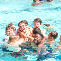 Kids wrestling in the pool at Camp Canaan.