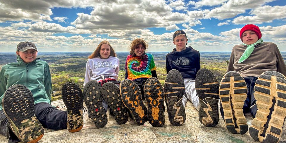 TLC campers line their feet up side-by-side overlooking valley below