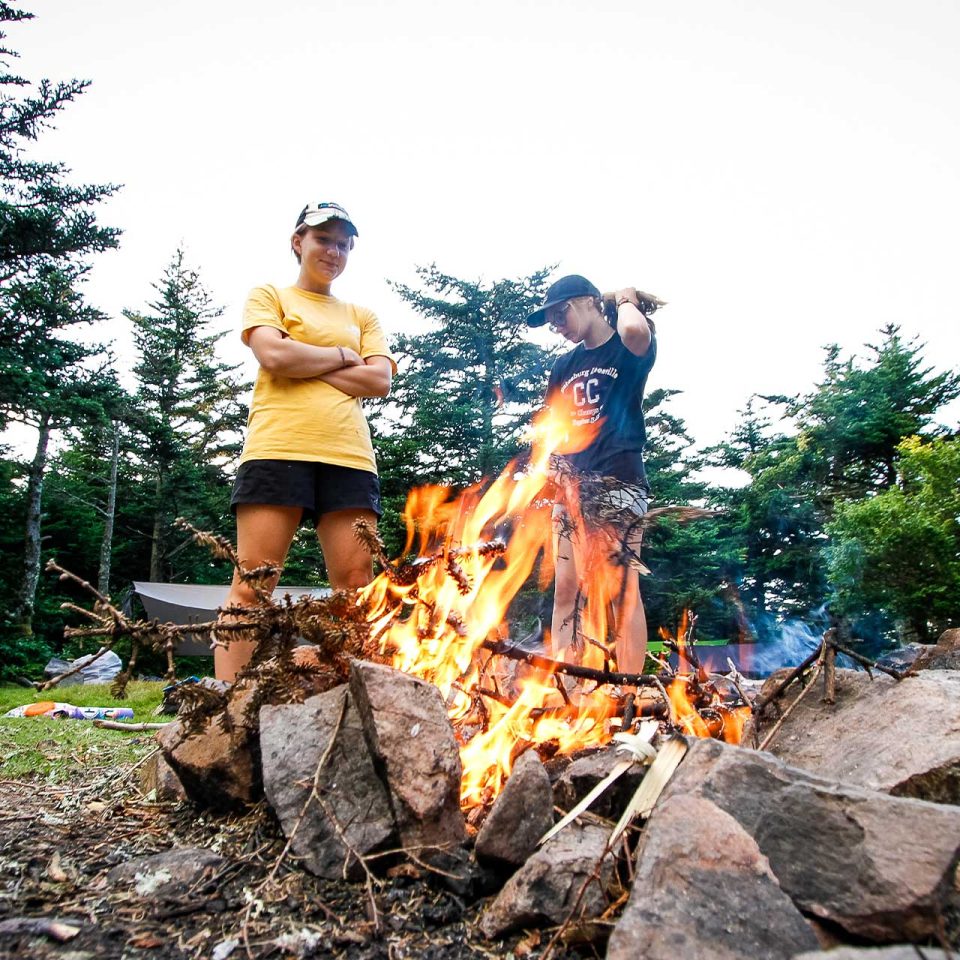 TLC counselor and camper stand watch over the bonfire