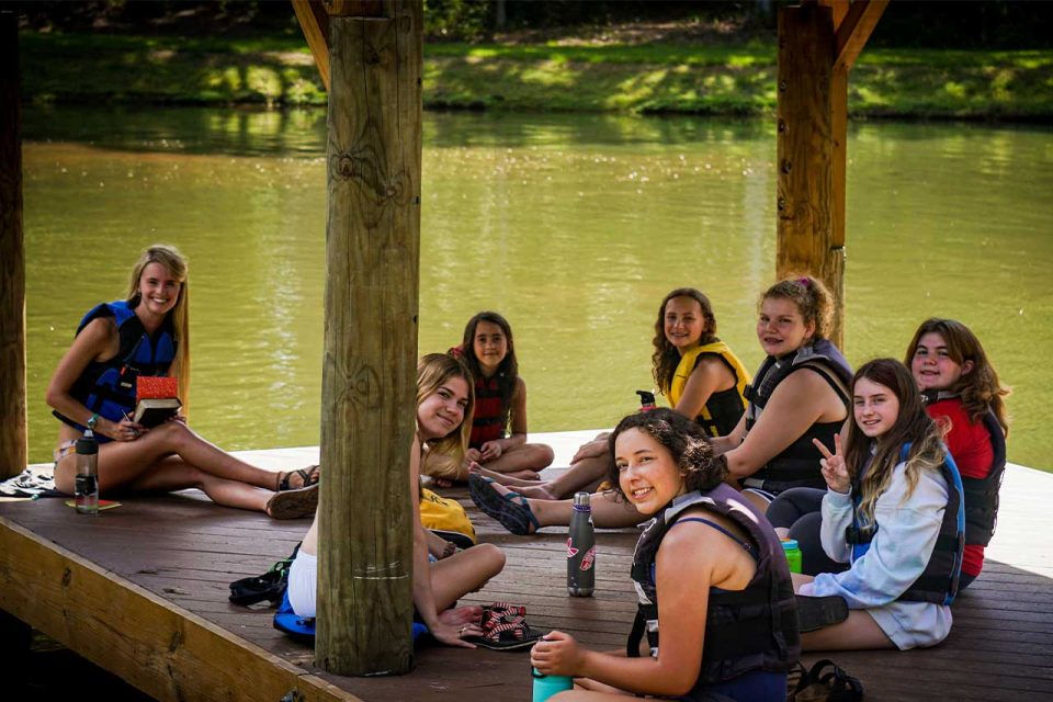 female counselor has devotional time with her campers on the deck overlooking Lake Canaan