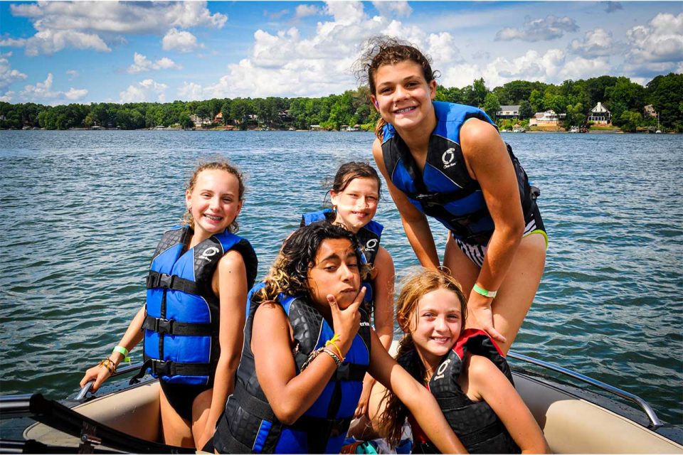 girl campers enjoy time on the boat at Lake Wylie during all girls camp