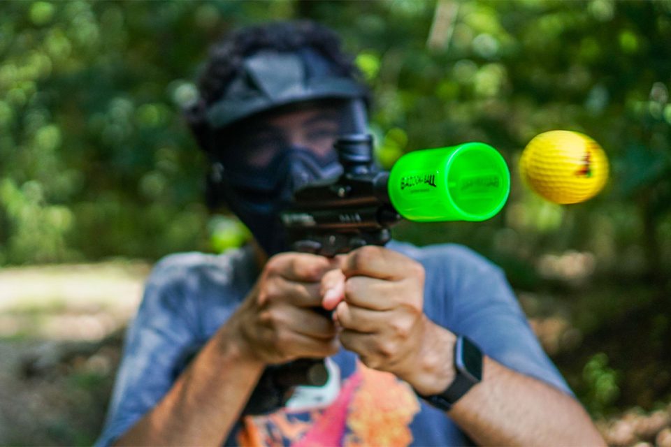 young man shoots yellow Bazooka ball out of Bazooka ball gun