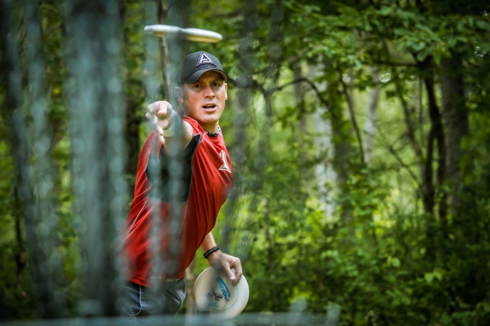 man in red shirt disc golfing at Camp Canaan