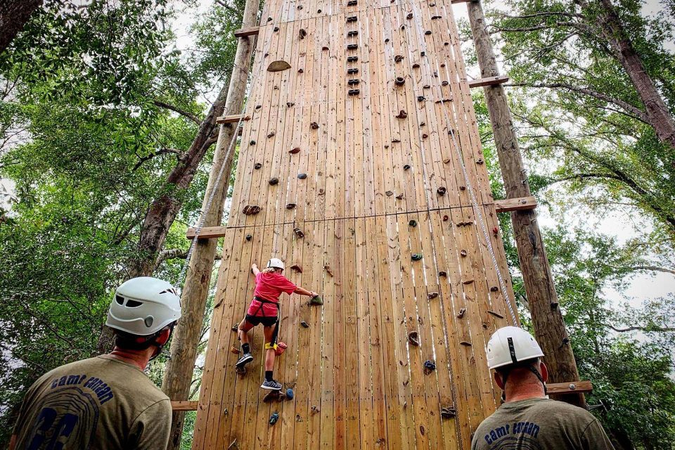 young camper in red shirt tries her hand at rock climbing on the Catawba tower