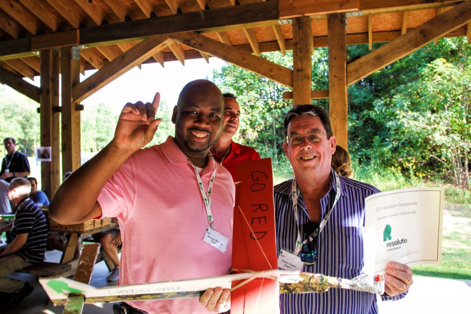 coworkers from Resolute celebrate their victory in the team building challenge at Camp Canaan