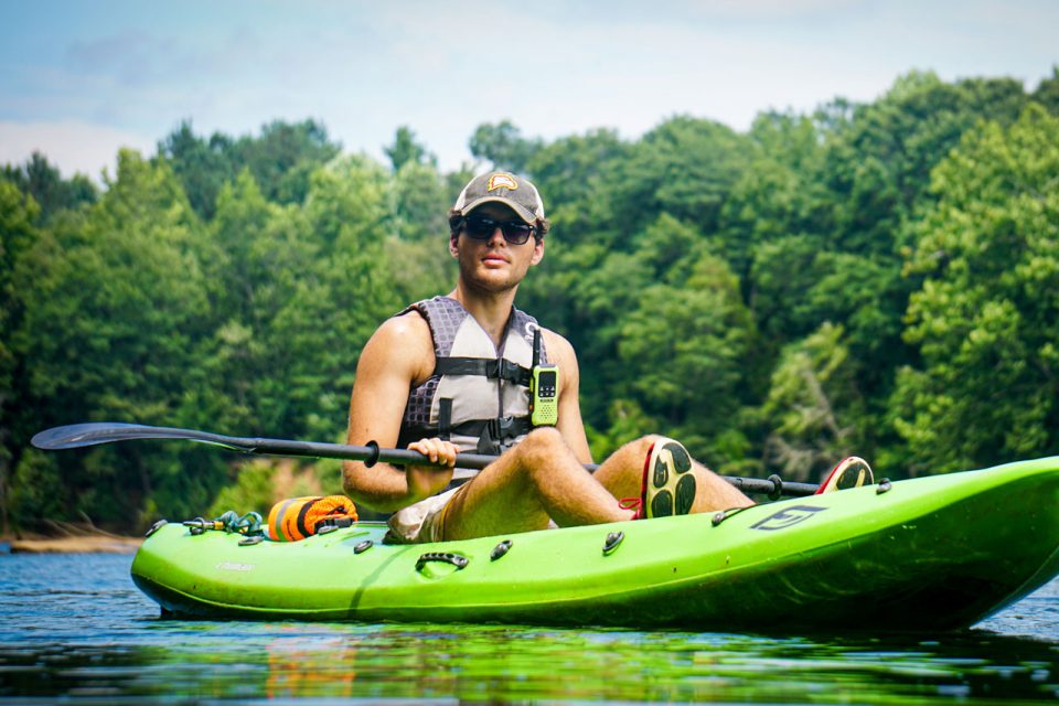 kayaking guide at Camp Canaan coasts down the Catawba River in a green kayak