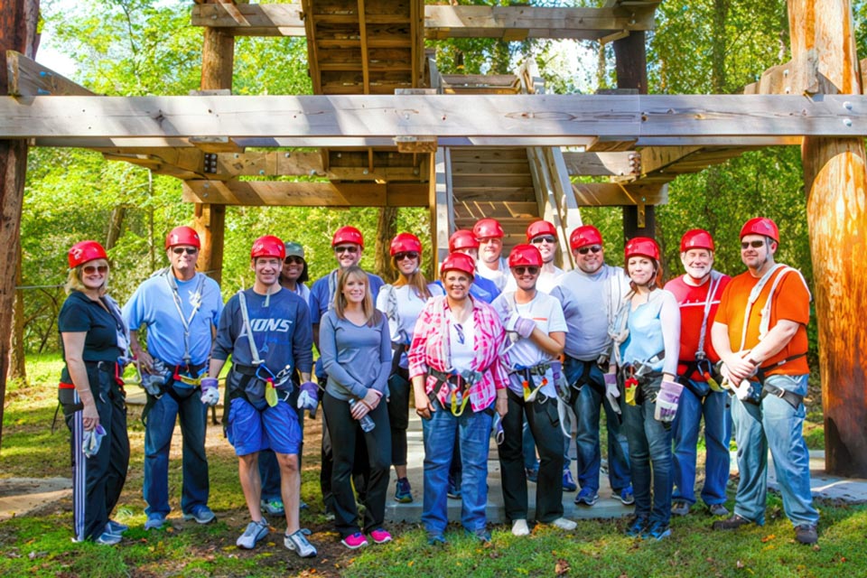 team stands in front of the Canaan zipline canopy tour tower before embarking on corporate team building activity