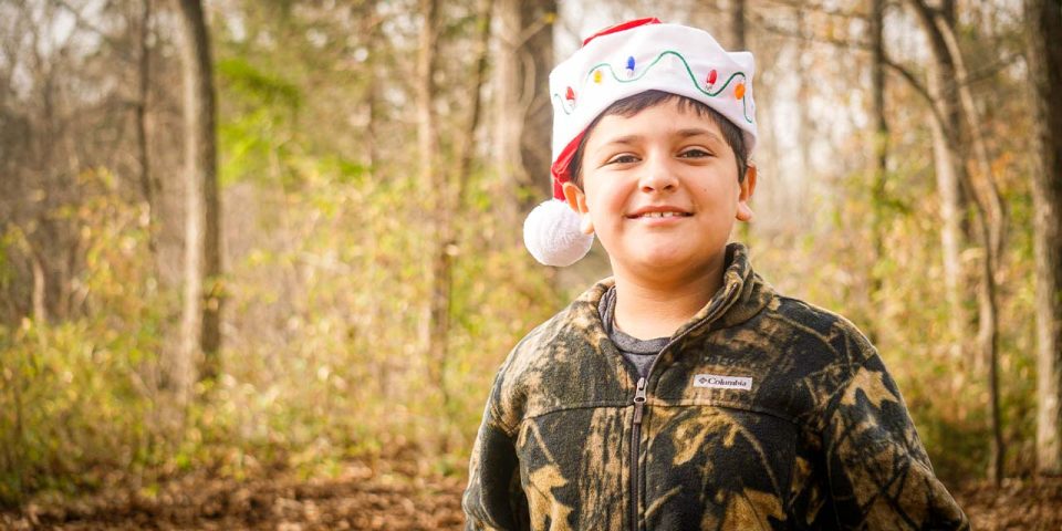 camper wears Santa hat during winter camp