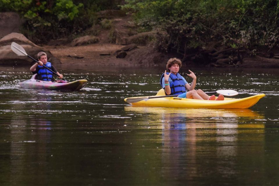 legacy campers coast down the catawba river in kayaks during summer camp at Camp Canaan