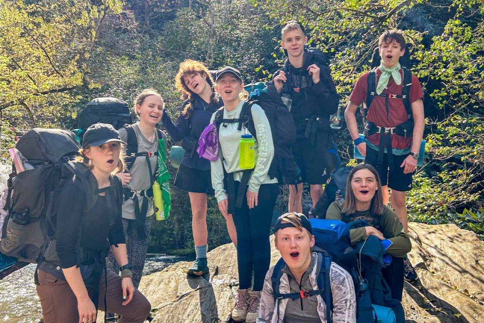 TLC counselor and campers make funny faces at the camera in the middle of their hike