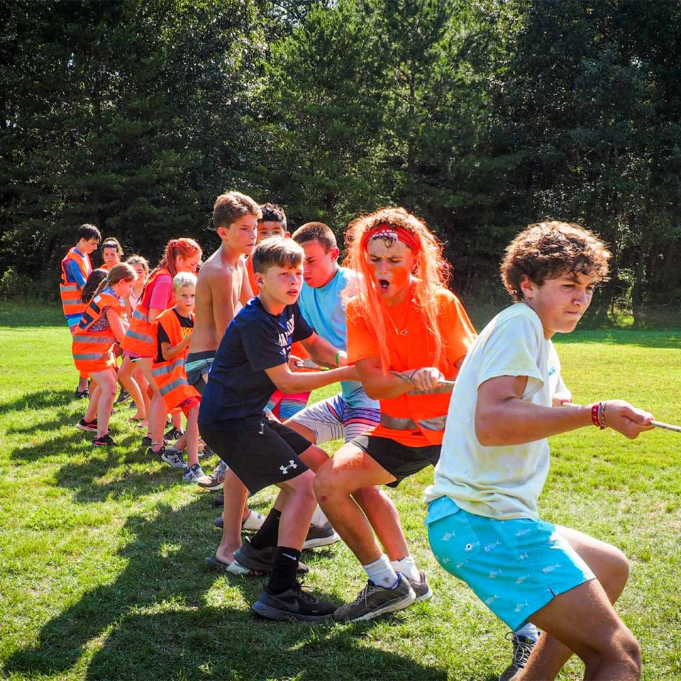 overnight campers play tug of war on the sports field of Camp Canaan during summer camp