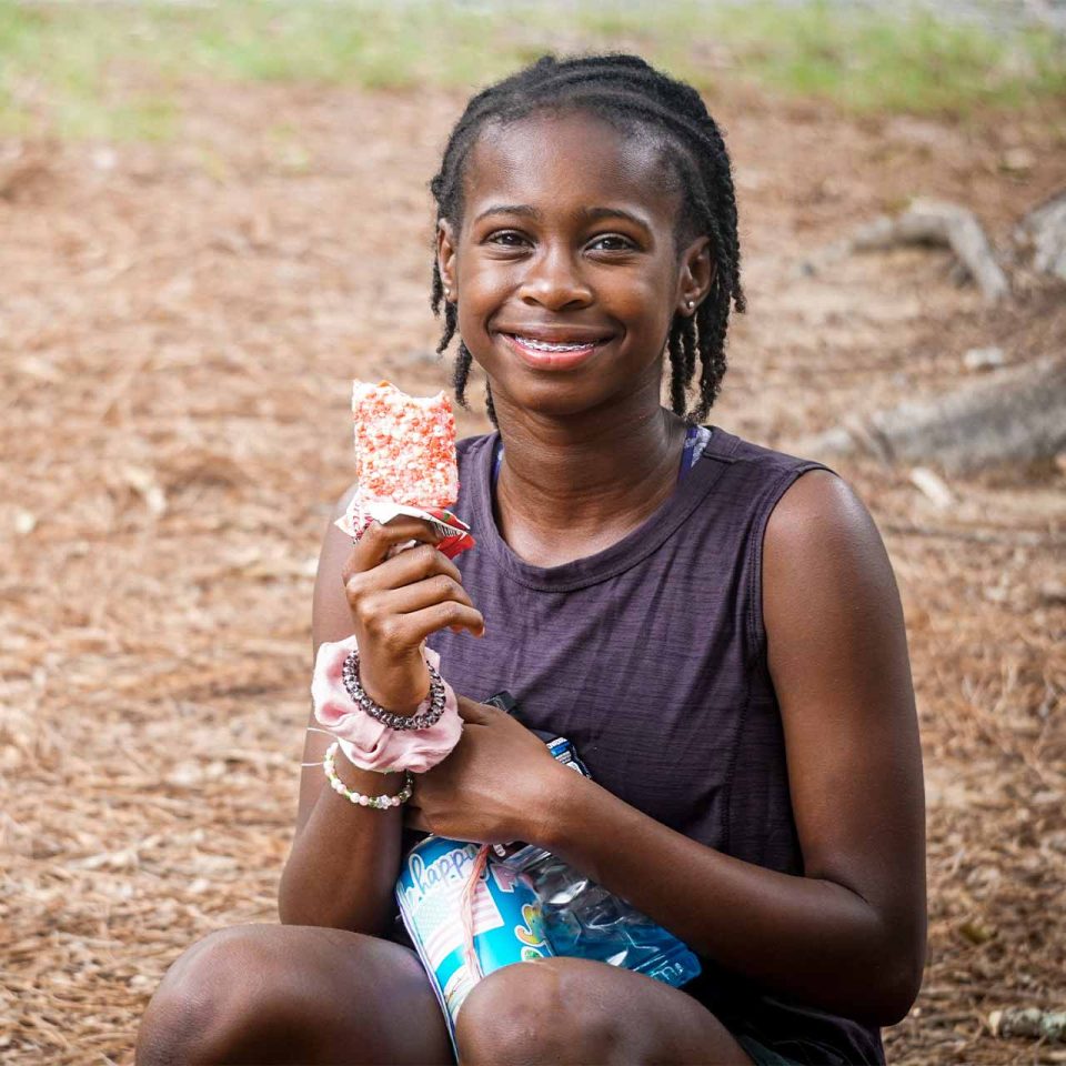 girl camper enjoys treat from canteen during all girls week at Camp Canaan