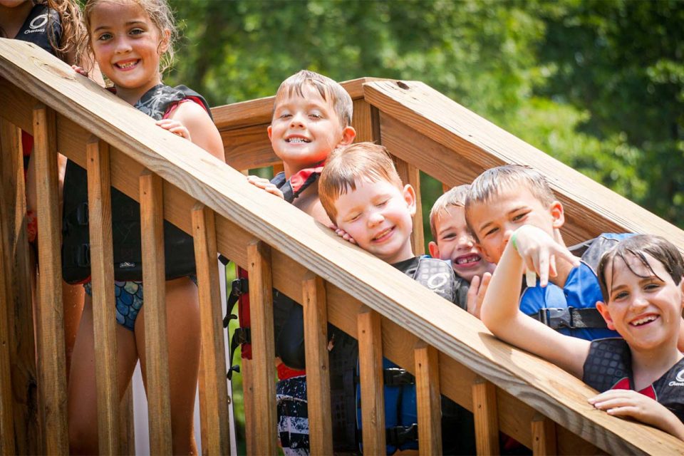 junior day campers line up on the stairs of the double decker dock at Camp Canaan