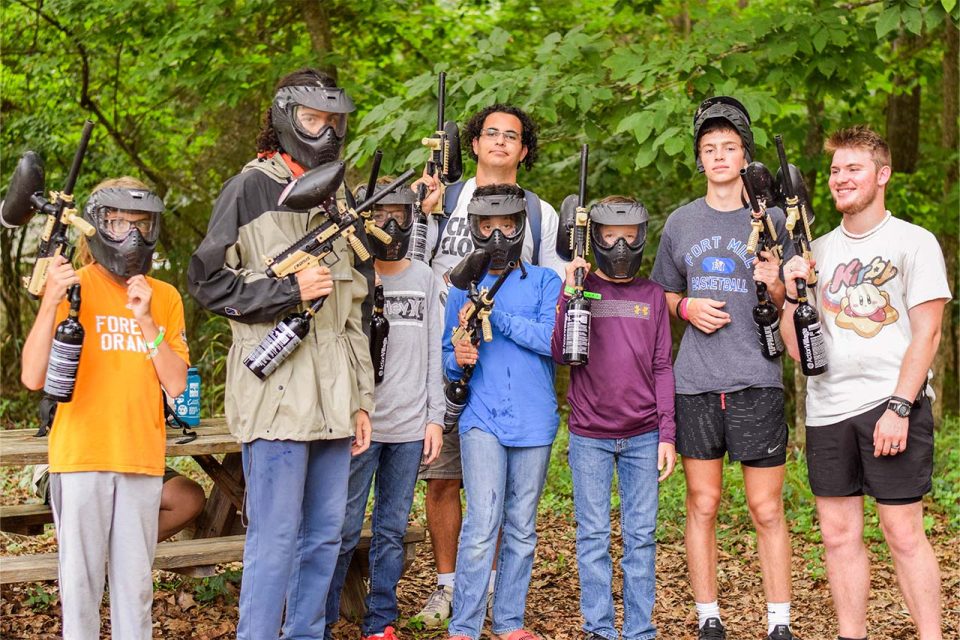 journey campers wearing paintball masks line up with counselors all holding paintball guns