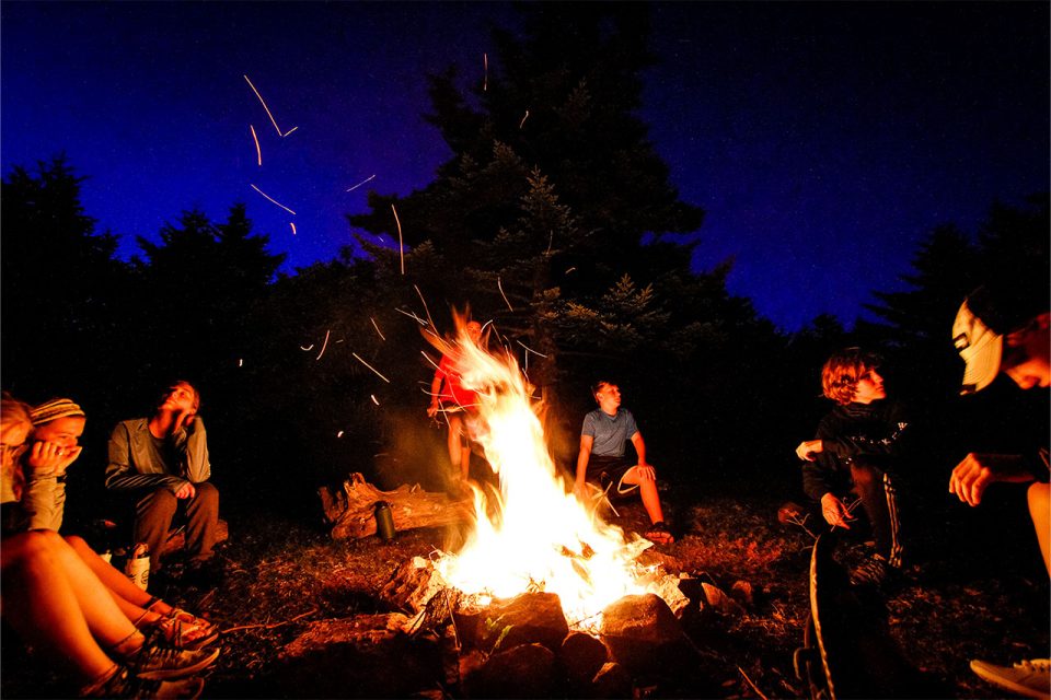 TLC campers gather around the bonfire at night