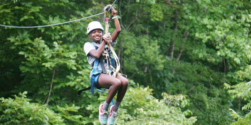 female senior day camper tries ziplining during summer camp at Camp Canaan