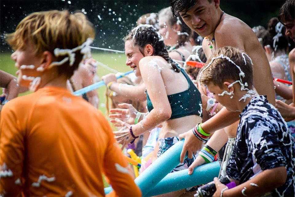 campers get covered with shaving cream during sludge war on sports fields at Camp Canaan