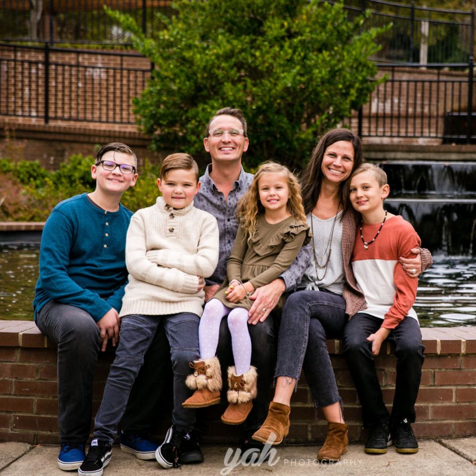 Nick and Tiffany Wimmer sit by a fountain with their four children, Kaison, Finn, Haven and Henley