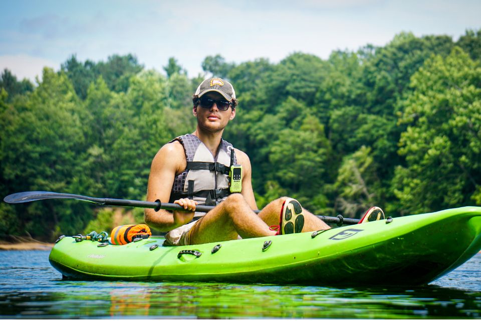 kayaking guide at Camp Canaan coasts down the Catawba River in a green kayak