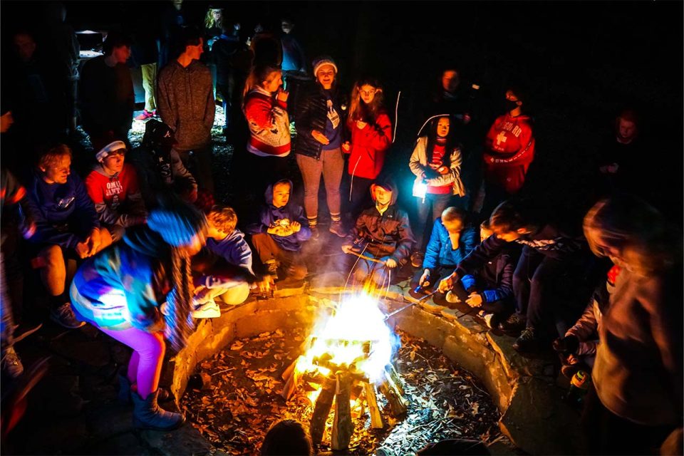 campers sit around fire pit at Camp Canaan